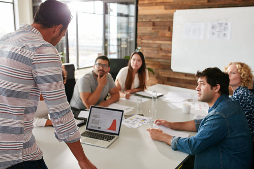 Young man giving business presentation to colleagues