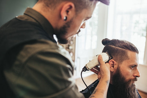 Hairdresser cutting hair of customer at salon
