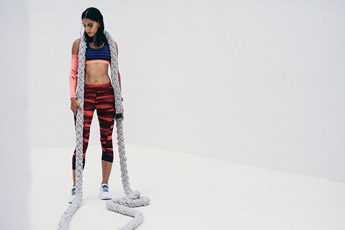 Fitness woman relaxing after workout with battle rope