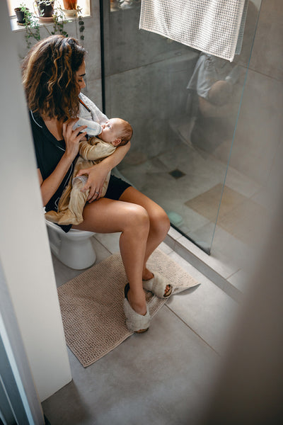 Mother feeds baby on toilet