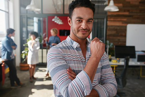 Confident young man standing in his office