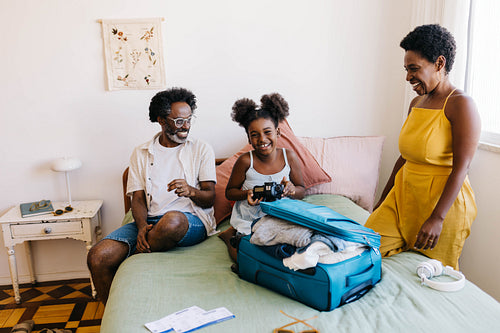 Family packing for vacation: Parents and daughter preparing for travel