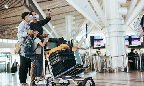 Family checking their flight timing at airport terminal