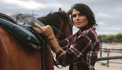 Saddling a brown horse