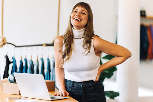 Successful business owner laughing cheerfully in her shop
