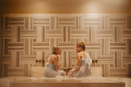 Mature woman and younger woman enjoying a luxurious hammam bath experience together