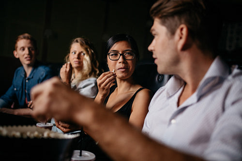 Friends sitting in multiplex movie theater