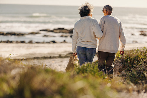 Romantic senior couple going to the beach for a picnic