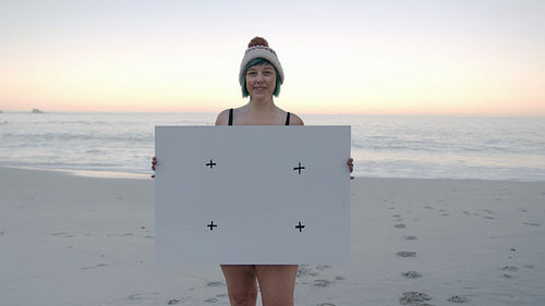 Happy woman with black poster on the beach