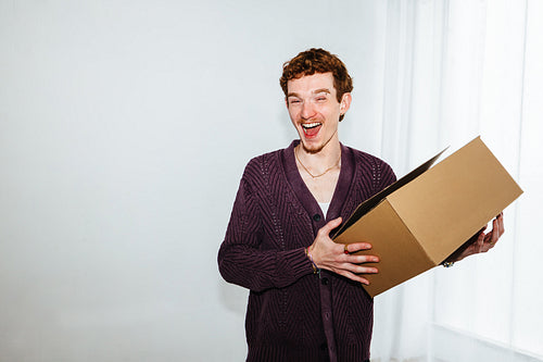Young man holding a package box for delivery, ecommerce order, and shipping service