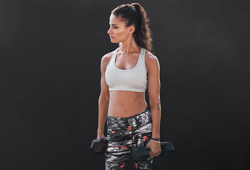 Slim and fit woman lifting hand weights