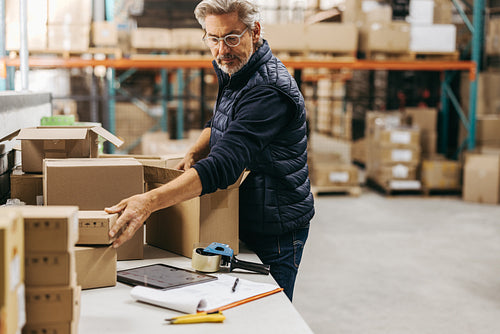 Senior warehouse worker packing orders