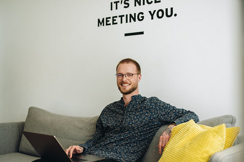 Businessman sitting on sofa and using laptop