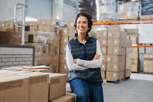 Cheerful warehouse manager looking away with a smile