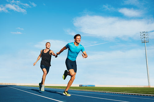 Athletes pass the baton in a track relay
