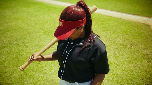 Female baseball player stands ready with bat