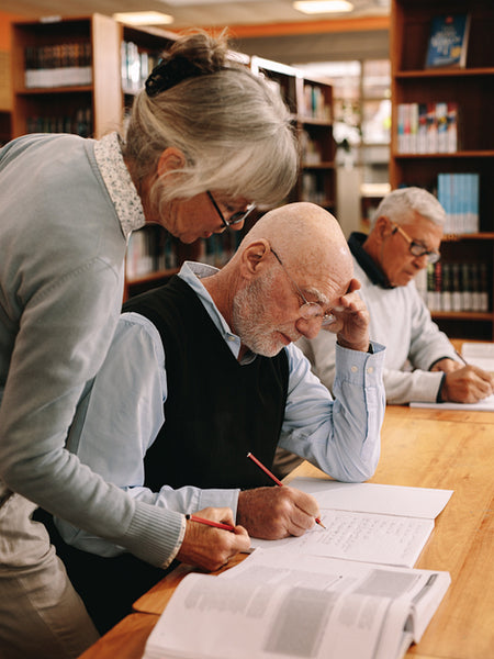 Close up of a senior female lecturer guiding an elderly student
