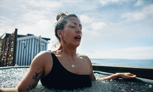 The woman builds resilience with a cold plunge in an outdoor ice bath.