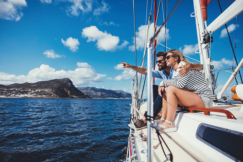 Young couple sitting on boat looking at a view