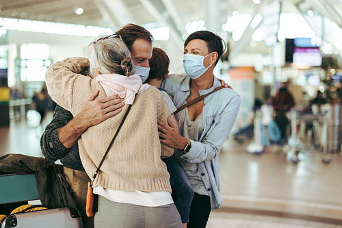 Grandmother meeting arriving family at airport