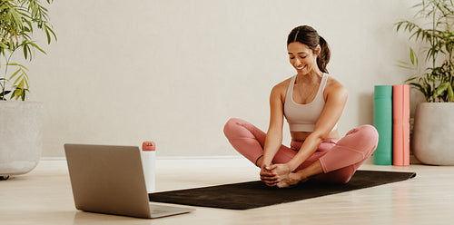 Woman exercising in fitness studio following online class