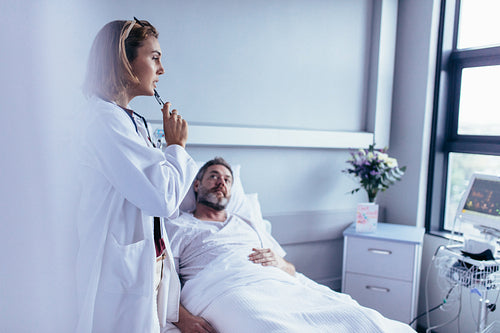 Doctor taking decision for treatment on hospitalised man.