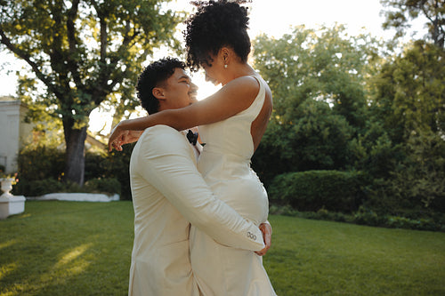 Newlyweds embracing in a lush garden on their special day