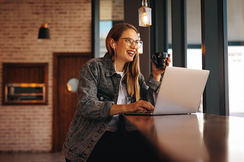 Woman enjoying working from a coffee shop