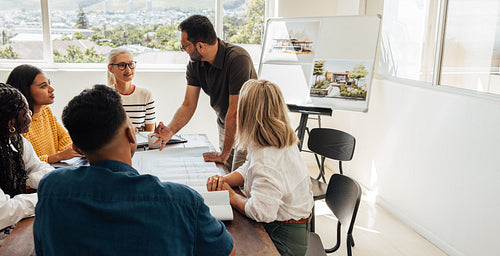 Architect team discussing building designs during a creative meeting in a bright office