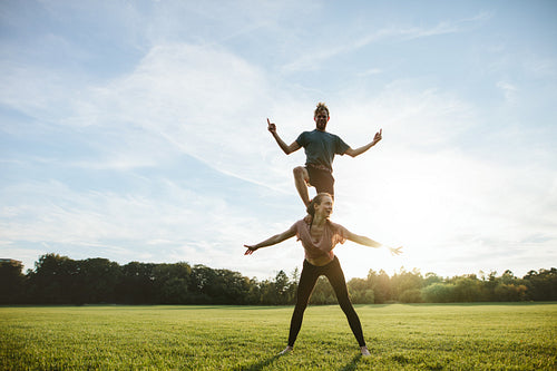 Strong young couple doing acrobatic yoga 
