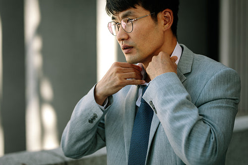 Businessman adjusting his necktie