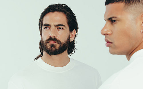 Two young men with radiant skin standing in a studio