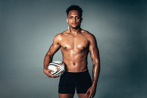 Fit young man holding rugby ball