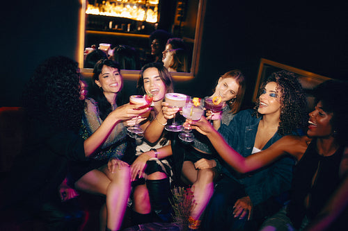 Group of friends enjoying a fun night out at a stylish cocktail bar