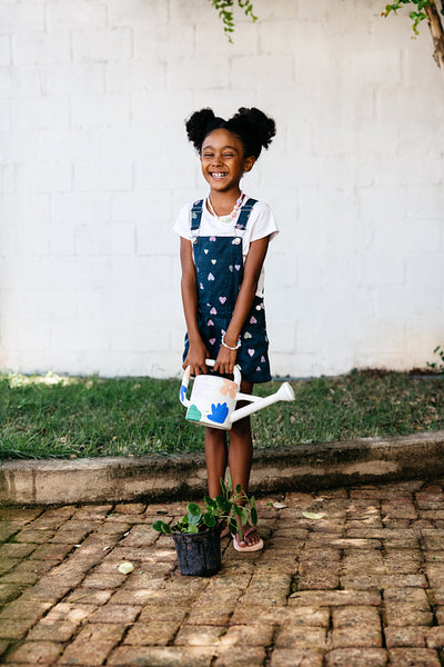 Young girl gardening with a smile outside