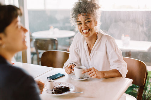 Cheerful busineswoman having coffee with her business partner