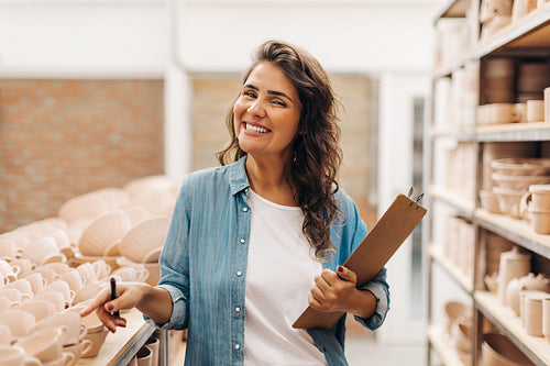 Successful businesswoman smiling at the camera in her ceramic store