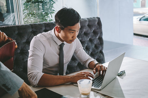 Businessman busy working on laptop at cafe