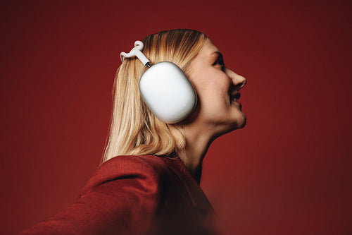 Her smiling woman profile brings music and headphones into a polished studio portrait