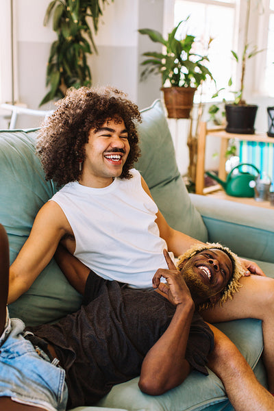 Happy gay couple relaxing together at home
