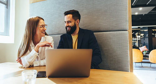 Young professionals smiling at each other in a modern workspace