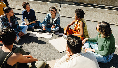 Group of young adults discussing social issues outdoors in a lively gathering