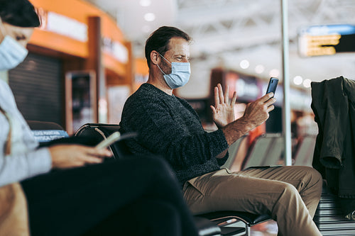 Traveler in face mask at airport doing video call