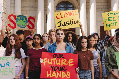 Multicultural teenagers holding a climate change demonstration