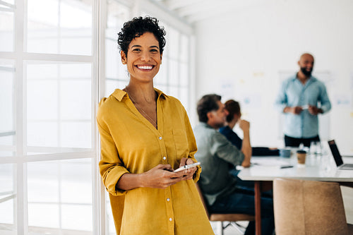 Female professional standing in an office and using a cellphone