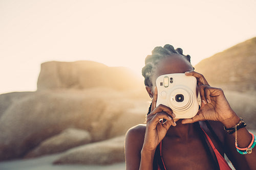 African american female taking pictures on the beach
