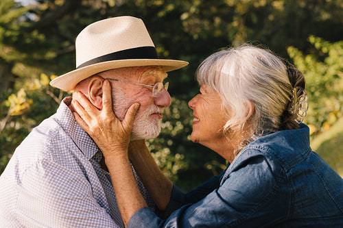 Grey-haired couple smiling at each other affectionately