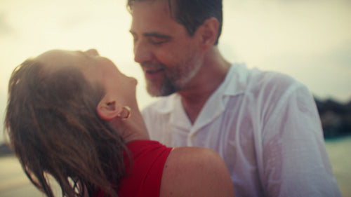 Loving couple embraces on a beautiful tropical beach at a romantic sunset