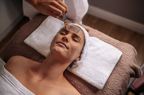 Female getting a facial mask treatment at beauty spa