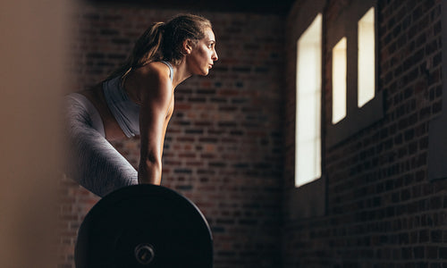 Athlete doing weight lifting exercise in gym